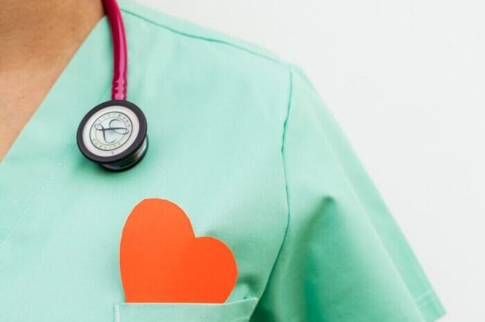 person wearing scrub suit with paper heart in the pocket